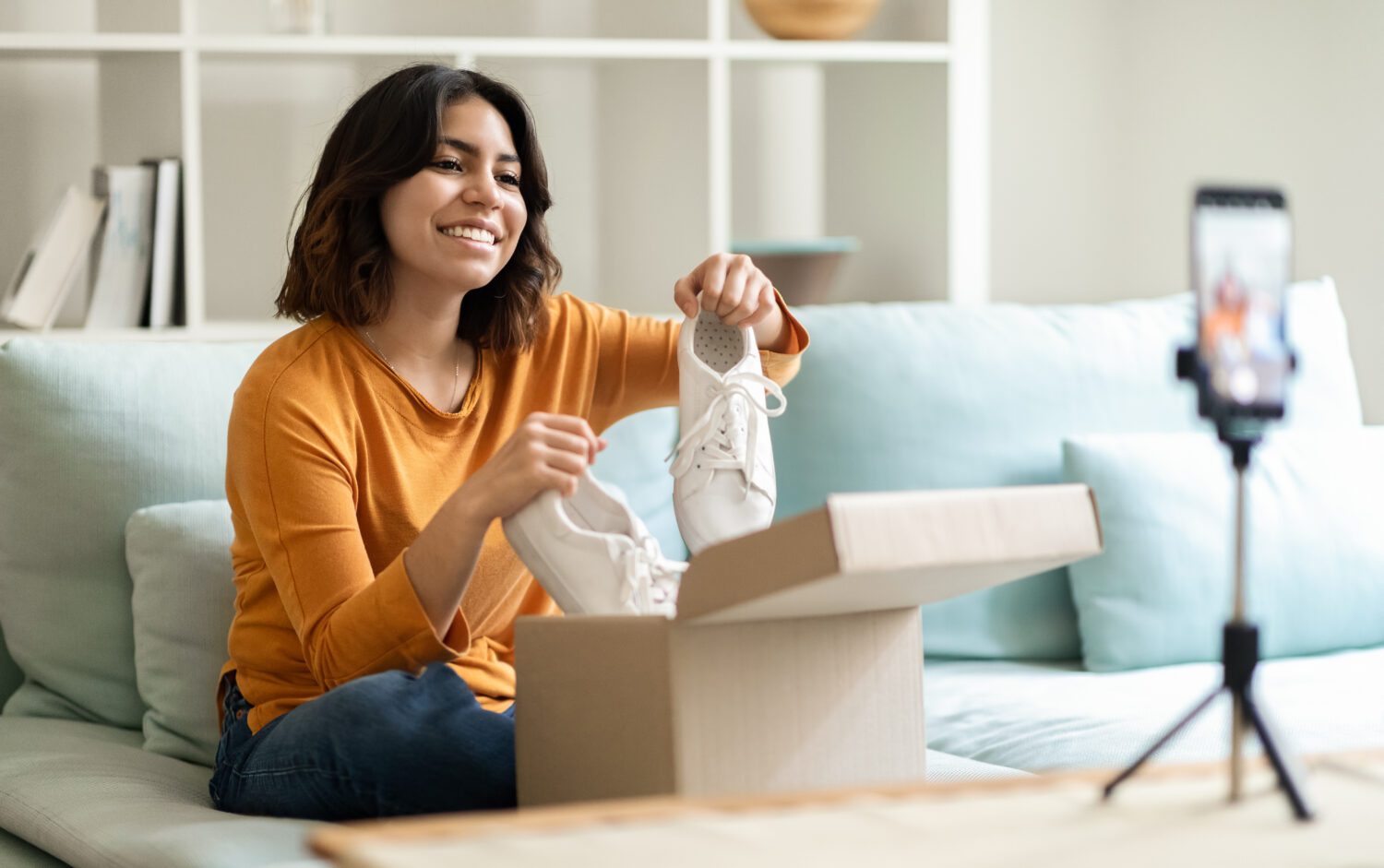 A woman films an unboxing video.